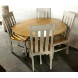 A contemporary oak circular drop leaf table and four half painted oak chairs.
