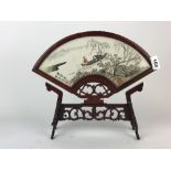 A Chinese embroidered fan shaped silk in a hardwood stand, H. 31cm.
