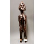 An African tribal carved hardwood female figure, H. 54cm.