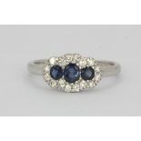 An 18ct white gold sapphire and diamond set cluster ring, (L).