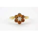 An 18ct yellow gold citrine and diamond set cluster ring, (O.5).