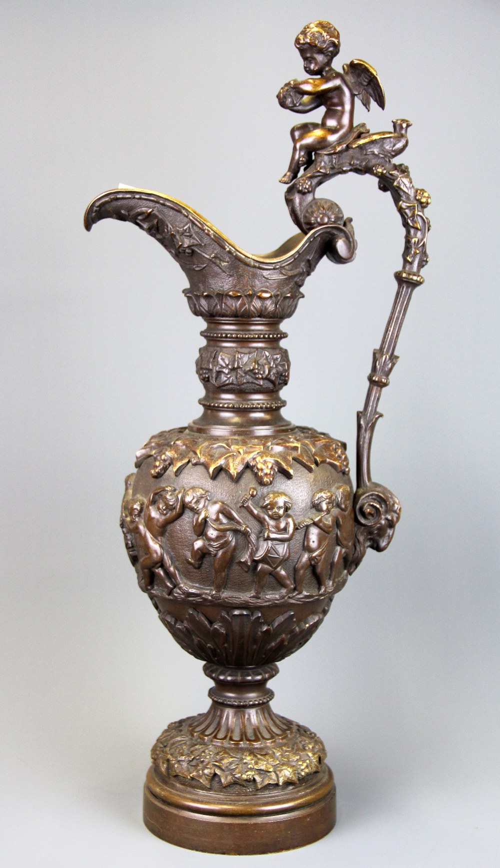 A large 19th Century bronze urn decorated with putti, H. 57cm.