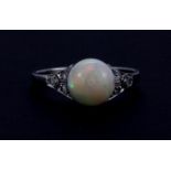 A 1920's platinum ring set with a polished opal sphere and diamonds, (N).