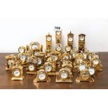 A large group of gilt brass miniature clocks.