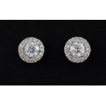 A pair of white metal (tested 18ct gold) diamond set halo stud earrings, approx. 1ct.