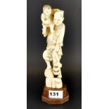 A 19th century carved Japanese ivory figure on a later wooden stand, L. 25cm.