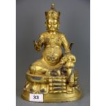A Tibetan gilt bronze figure of a seated deity, H. 26cm.