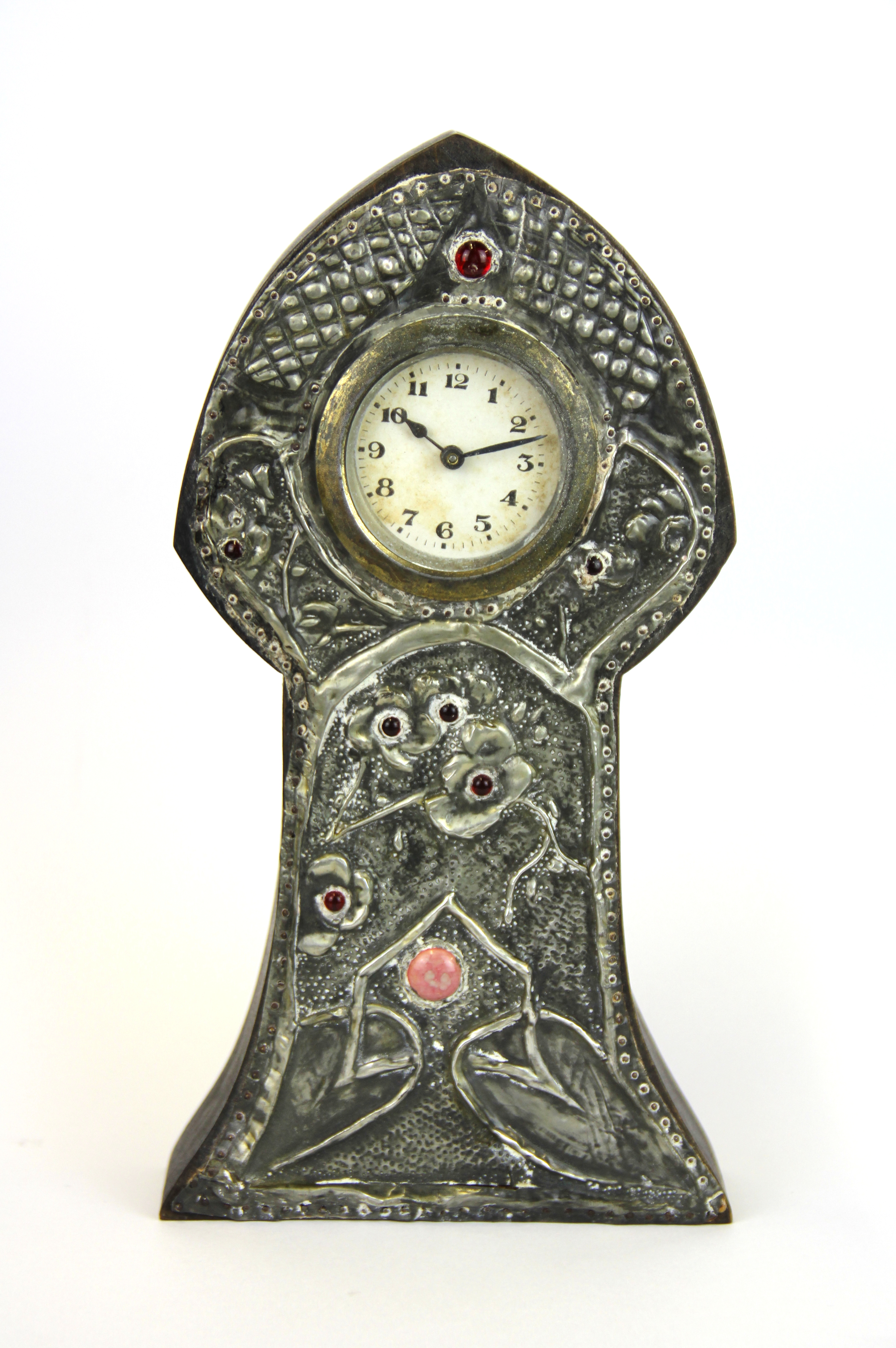 An early 20th Century Arts and Crafts hammered pewter decorated clock, H. 25cm.