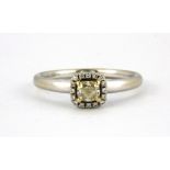 An 18ct white gold ring set with an 0.40ct cushion cut fancy light yellow diamond surrounded by
