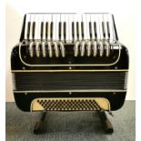 A Max Crimm piano accordion and stand, understood to be in working order.