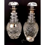 A pair of hallmarked silver collared cut crystal decanters with hallmarked silver labels, H. 28cm.