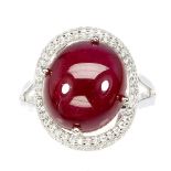 A 925 silver ring set with a large cabochon cut ruby surrounded by white stones, (P).