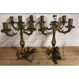 A pair of heavy brass candelabra, H. 28cm, together with a pair of brass cherubs on swings.