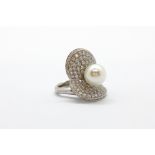 An 18ct white gold (stamped 750) adjustable ring set with brilliant cut diamonds and a pearl,