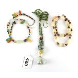 A necklace of mixed coloured jade beads, together with two further semi-precious stone necklaces.