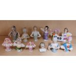 A group of twelve small porcelain half dolls, tallest 6cm.