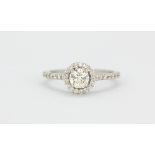 An 18ct white gold (stamped 750) halo ring set with a brilliant cut diamond surrounded by