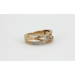 A 9ct yellow gold diamond set crossover ring, (O).