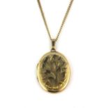 A 9ct yellow gold locket pendant on a yellow metal (tested 9ct gold) chain, L. 4cm.
