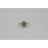 An 18ct yellow and white gold sapphire and diamond set cluster ring, (K).