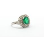 A 14ct white gold (stamped 585) ring set with an octagonal cut 1.42ct natural emerald surrounded