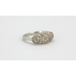 A 10ct white gold (stamped 10k) diamond set triple cluster ring, (J).