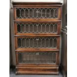 A four section oak leaded glass Globe Wernicke bookcase, H. 141cm, W. 87cm, (one small crack to
