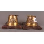 A pair of brass military ashtrays on oak stands, Royal Artillery, H. 6cm.