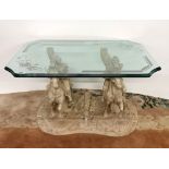 A heavy plate glass top coffee table with stone resin pedestal base of two knights on horseback,