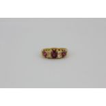 An 18ct yellow gold ring set with old cut rubies and diamonds, (O).