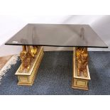 A smoked plate glass topped Egyptian theme coffee table, 76 x 65 x 41cm, (minor chip to one corner