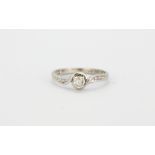 A 9ct white gold diamond set solitaire ring with diamond set shoulders, (M).