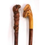 Two interesting carved wooden walking sticks, one with glass eyes, longest is 143cm (hiking stick)