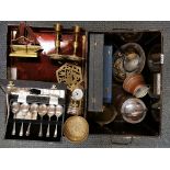 A metal trunk containing brass candlesticks, cutlery and other items.