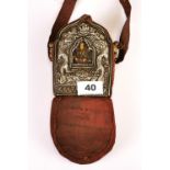 A Tibetan hammered white metal and copper ga'u (portable shrine) containing a hand painted clay