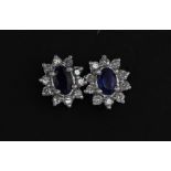 A pair of 18ct white gold (stamped 750) stud earrings set with oval cut sapphires and diamonds, L.