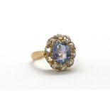 A rose metal (tested high carat gold) ring set with a natural oval cut sapphire surrounded by old