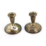 A pair of weighted sterling silver candlesticks, H. 10cm.