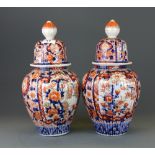 A pair of 19th Century Japanese Imari porcelain jars and covers, H. 33cm.