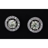 A pair of 18ct white gold (stamped 750) halo earrings set with brilliant cut diamonds, they