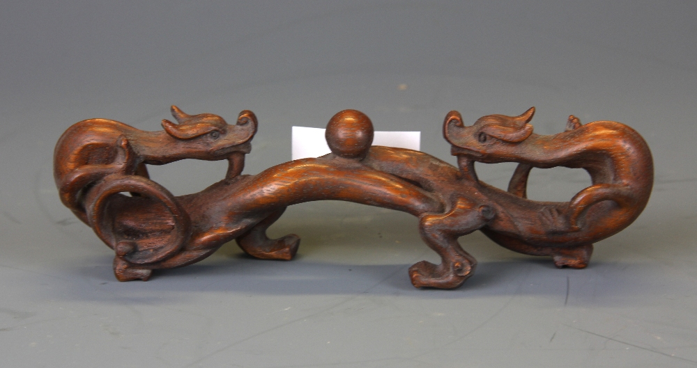 A Chinese carved wooden dragon brush rest, W. 17cm.