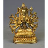 A Tibetan gilt bronze figure of a seated multi-arm deity, H. 12cm.