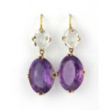 A pair of yellow metal (tested 9ct gold) drop earrings set with oval cut amethysts and rock crystal,