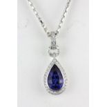 An 18ct white gold (stamped 750) pendant and chain set with a pear cut sapphire and brilliant cut