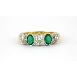 An 18ct yellow and white gold ring set with oval cut emeralds and old cut diamonds, (P.5).