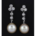 A pair of 18ct white gold (stamped 750) drop earrings set with cream pearls and brilliant cut