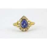 An 18ct yellow gold (stamped 18ct) ring set with a pear cut sapphire surrounded by single cut