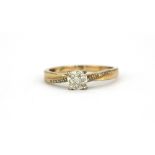 A yellow metal (tested 9ct gold) diamond set cluster ring with diamond set shoulders, (P).