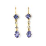 A pair of yellow metal (tested 9ct gold) drop earrings set with oval cut tanzanites and diamonds, L.