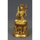 A small Tibetan gilt bronze figure of a seated Tara, H. 13m.